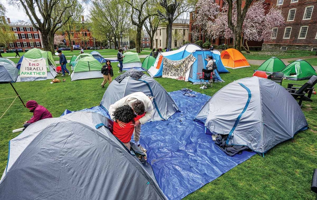 Image of tents, students, and signs on the campus green encampment.