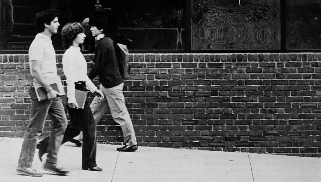 Archival image of students walking by the mirror glass of the 1984 BioMed Center