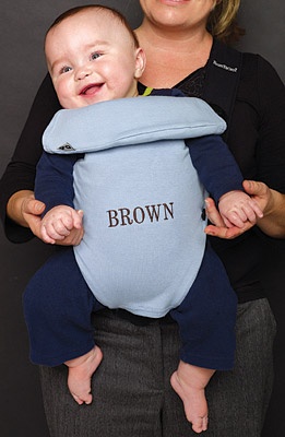 Photo of a baby in a carrier that is embroidered "BROWN".