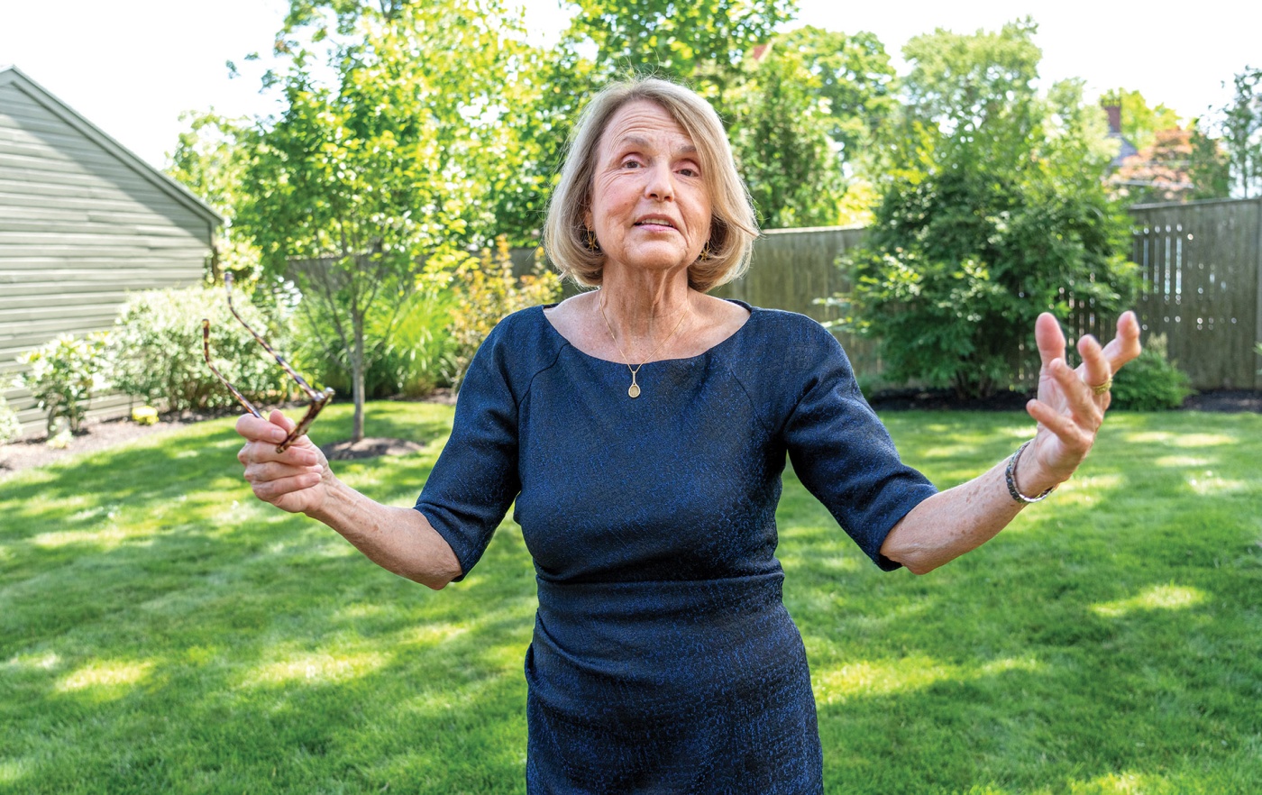 Image of Tracy Breton mid-explanation with green grass and trees in the background. 