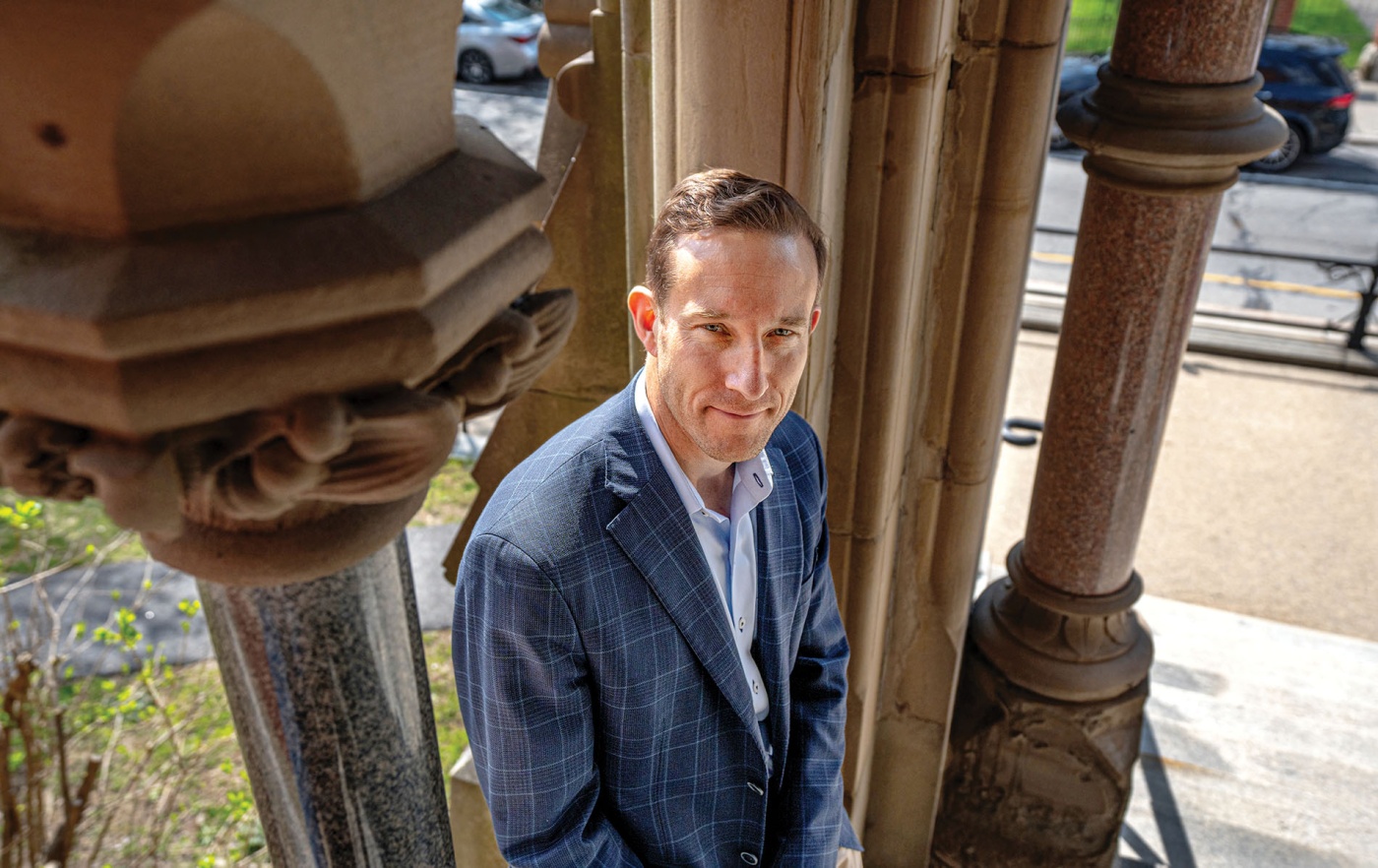 Image of John Friedman sitting by columns outside Robinson Hall.