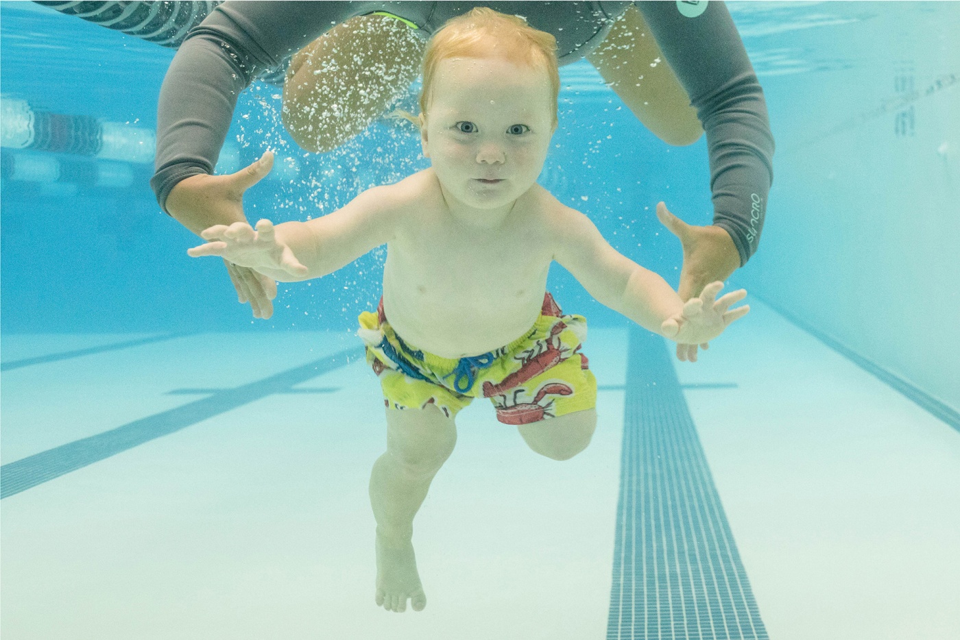 Image of a baby swimming under water in a pool.