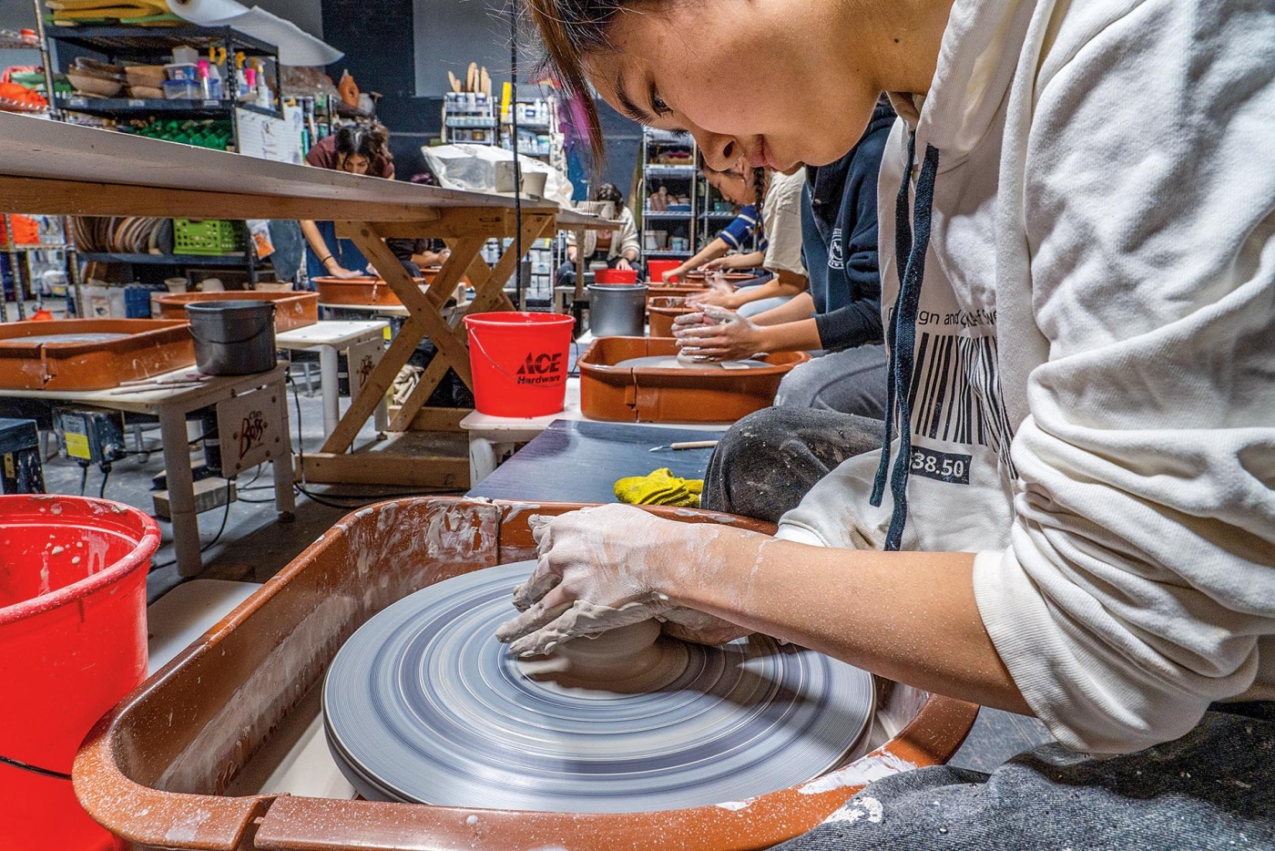 Image of a student using a pottery wheel in a studio