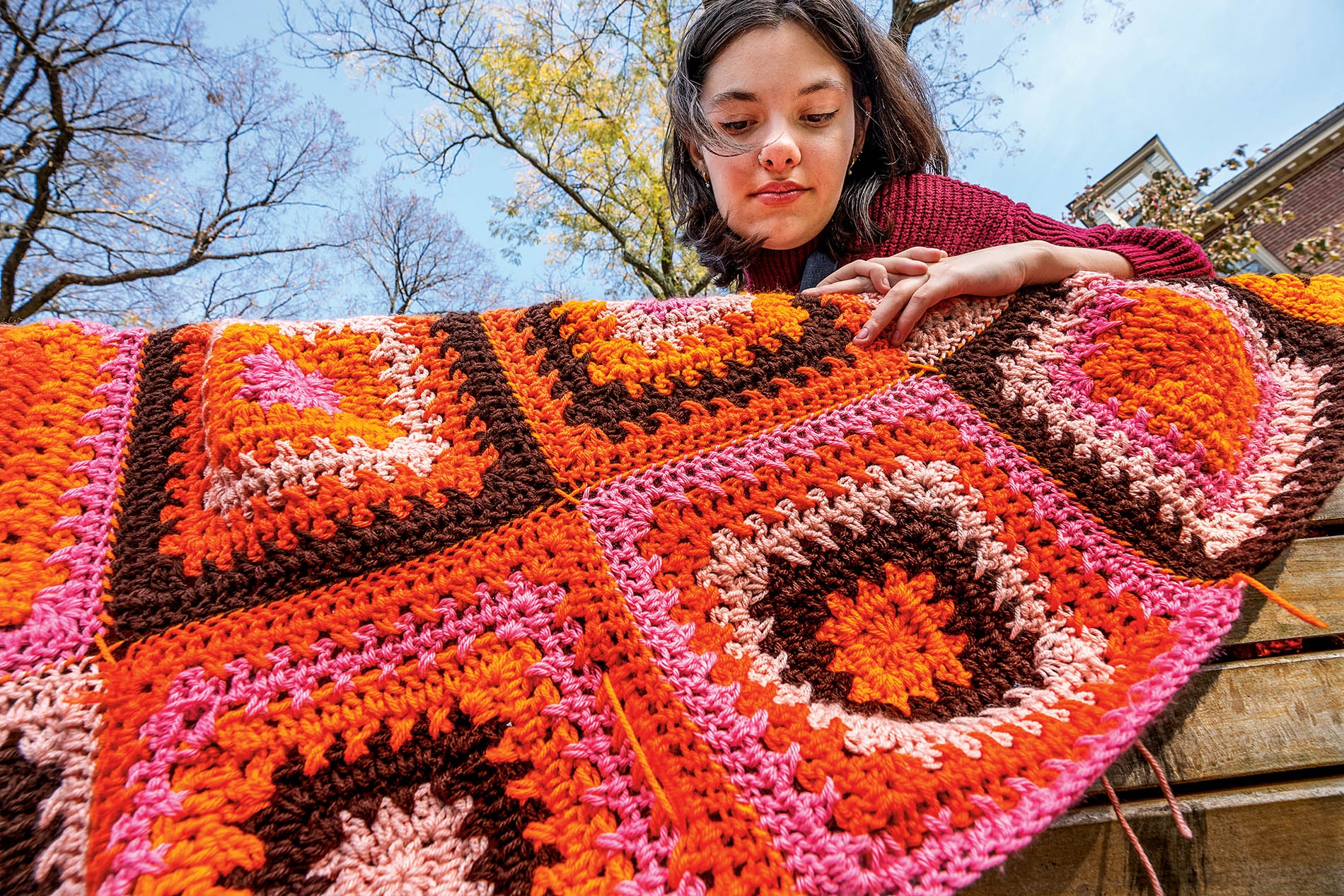 Image of Rachel Kamphaus holding a crocheted blanket 