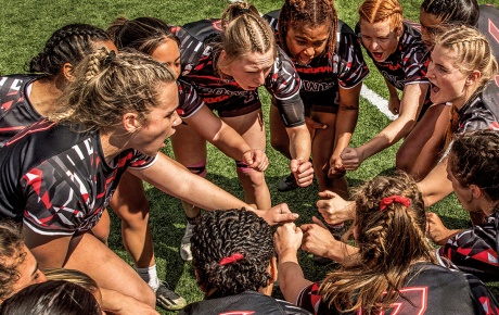 photo of the Brown women's Rugby Team huddling during a game