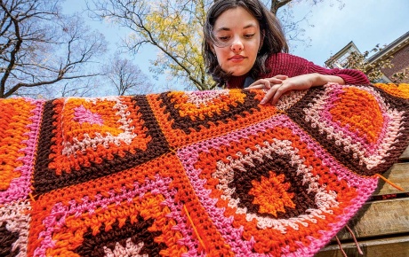 Image of Rachel Kamphaus holding a crocheted blanket 